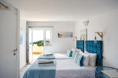 a bedroom with a large bed with a blue headboard at AltaVista Lodge in Luz