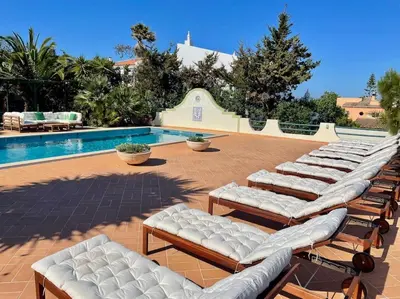 a row of lounge chairs next to a swimming pool at AltaVista Lodge in Luz