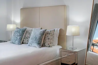 a bedroom with a white bed with pillows and a window at Pena II by An Island Apart in Funchal