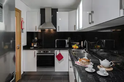 a kitchen with white cabinets and a sink at Pena II by An Island Apart in Funchal