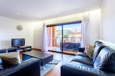 a living room with a couch and a tv at Rock and Sea - Baia da Luz in Luz