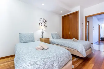 a bedroom with two beds and a chair at Rock and Sea - Baia da Luz in Luz