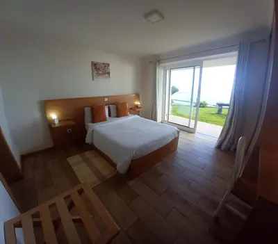 a bedroom with a bed and a large window at CASA SOL E VISTA 2 in Arco da Calheta