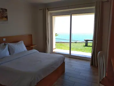 a bedroom with a bed and a large sliding glass door at CASA SOL E VISTA 2 in Arco da Calheta
