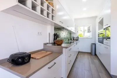 a kitchen with white cabinets and a counter at Paraíso dos Pássaros in Budens