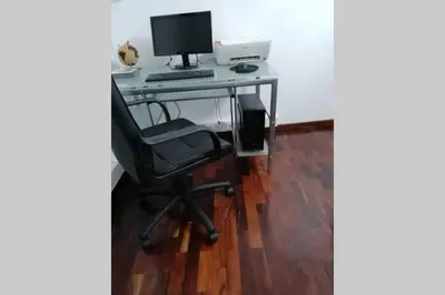 a desk with a computer monitor and a chair at Vila Relax Vacation Rental, Funchal in Funchal