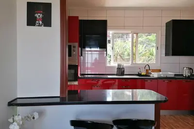 a kitchen with red cabinets and a black counter top at Vila Relax Vacation Rental, Funchal in Funchal