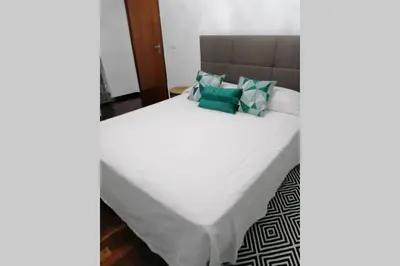 a bedroom with a large white bed with blue pillows at Vila Relax Vacation Rental, Funchal in Funchal