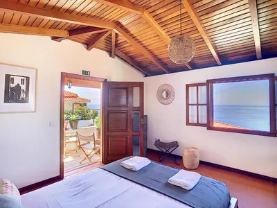 a bedroom with a bed and a view of the ocean at Pôr do Sol by LovelyStay in Calheta