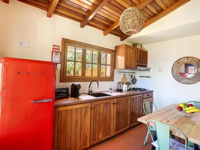 a kitchen with a red refrigerator and a table at Pôr do Sol by LovelyStay in Calheta