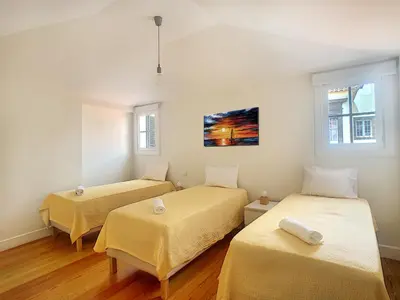 a room with two beds and two windows at Casa Conceição by LovelyStay in Funchal