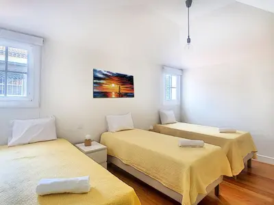 two beds in a room with yellow sheets at Casa Conceição by LovelyStay in Funchal