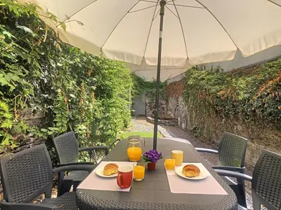 a table with plates of food and an umbrella at Casa Conceição by LovelyStay in Funchal