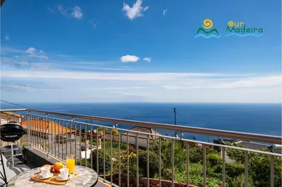 a balcony with a table and a view of the ocean at OurMadeira - SeaView Apartment in Calheta