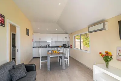 a kitchen and living room with a table and a couch at OurMadeira - SeaView Apartment in Calheta