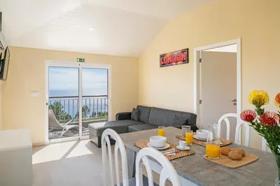 a living room with a table and a couch at OurMadeira - SeaView Apartment in Calheta