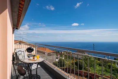 a balcony with a table and a view of the ocean at OurMadeira - SeaView Apartment in Calheta