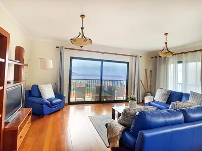 a living room with blue furniture and a large window at Gemini Apartment by LovelyStay in Funchal