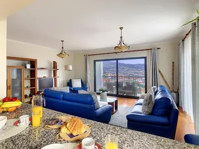 a living room with blue couches and a large window at Gemini Apartment by LovelyStay in Funchal