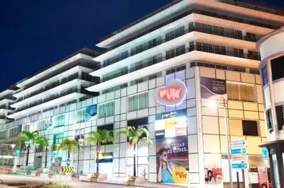 a large building with palm trees in front of it at Comfortable 2-Bedroom Apartment for Relaxing Stays in Funchal