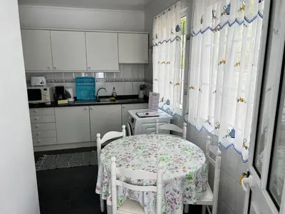 a kitchen with a table and two chairs in a kitchen at Comfortable 2-Bedroom Apartment for Relaxing Stays in Funchal