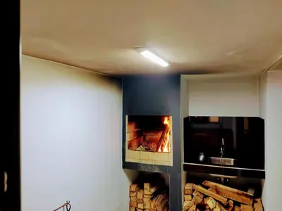 a fireplace in a room with a pile of wood at Zoe House in Paul do Mar