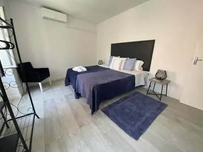 a bedroom with a bed with a blue blanket and a chair at Zoe House in Paul do Mar