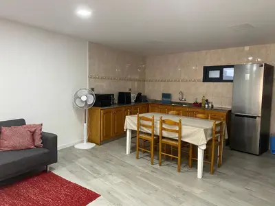 a kitchen with a table with chairs and a refrigerator at Zoe House in Paul do Mar
