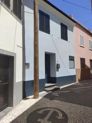 a building with a number painted on the street at Zoe House in Paul do Mar