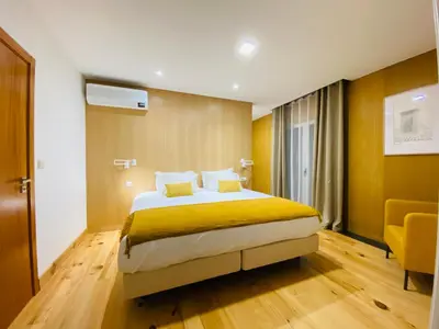 a bedroom with a bed and a yellow wall at Villas Calhau da Lapa 51 in Campanário