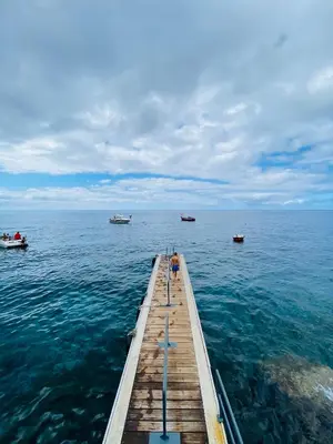 a dock in the ocean with boats in the water at Villas Calhau da Lapa 51 in Campanário