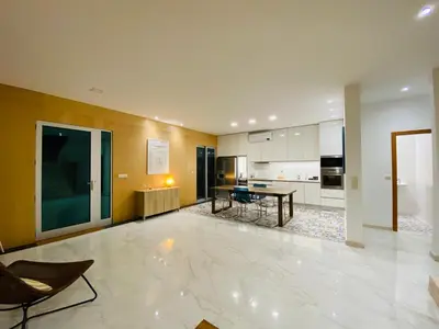 a large living room with a table and a kitchen at Villas Calhau da Lapa 51 in Campanário
