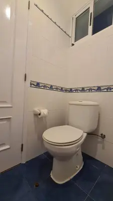 a bathroom with a white toilet and a window at Casa da Avó Duca in Machico