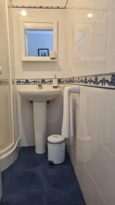 a bathroom with a sink and a toilet and a mirror at Casa da Avó Duca in Machico