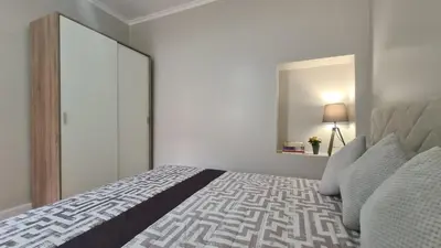 a white bedroom with a bed and a mirror at Casa da Avó Duca in Machico