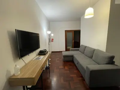 a living room with a couch and a table with a television at Shining in Funchal