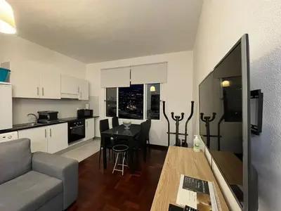 a kitchen and living room with a couch and a table at Shining in Funchal