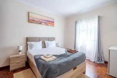 a bedroom with a large bed and a window at Flowers island house 3 in Caniço
