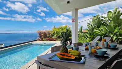 a table with a tray of fruit next to a swimming pool at Villa Estrelícia by LovelyStay in Ribeira Brava