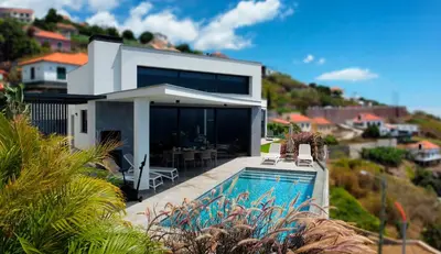 a house with a swimming pool in front of a house at Villa Estrelícia by LovelyStay in Ribeira Brava