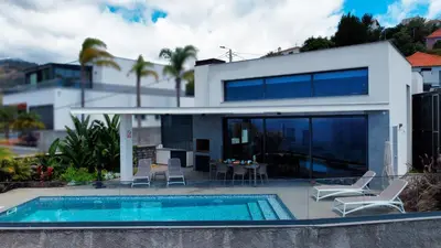 a house with a swimming pool in front of it at Villa Estrelícia by LovelyStay in Ribeira Brava