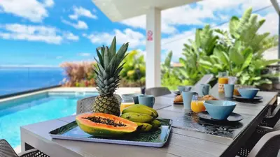 a table with a plate of fruit next to a pool at Villa Estrelícia by LovelyStay in Ribeira Brava