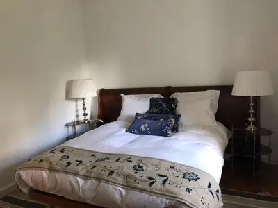 a bed with two pillows on it with two lamps at Quintinha de Palmyra in Camacha