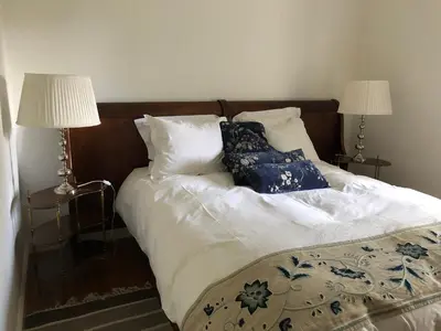 a bed with two pillows and two lamps on it at Quintinha de Palmyra in Camacha