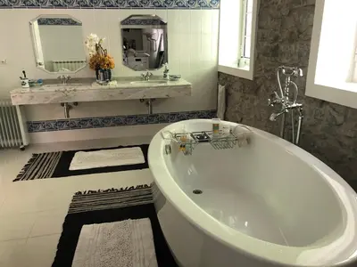 a white bath tub in a bathroom with a sink at Quintinha de Palmyra in Camacha