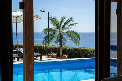 a view of the ocean from a room with a swimming pool at GALVÃO HOUSE EXPERIENCE in Ribeira Brava
