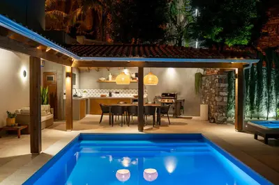 a swimming pool in the middle of a patio with a table and a kitchen at GALVÃO HOUSE EXPERIENCE in Ribeira Brava