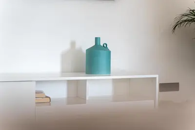 a white shelf with a blue vase on it at GALVÃO HOUSE EXPERIENCE in Ribeira Brava