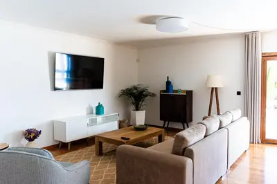 a living room with a couch and a tv at GALVÃO HOUSE EXPERIENCE in Ribeira Brava