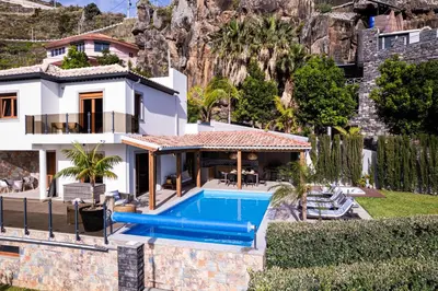 a villa with a swimming pool and a house at GALVÃO HOUSE EXPERIENCE in Ribeira Brava
